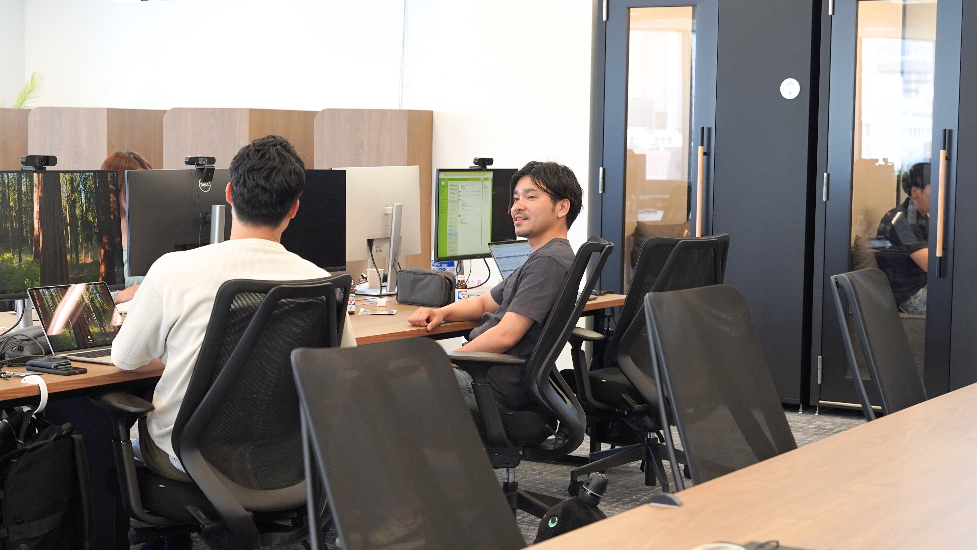 人員拡大に伴い移転したばかりのfindのオフィスでメンバーと会話する高島さん